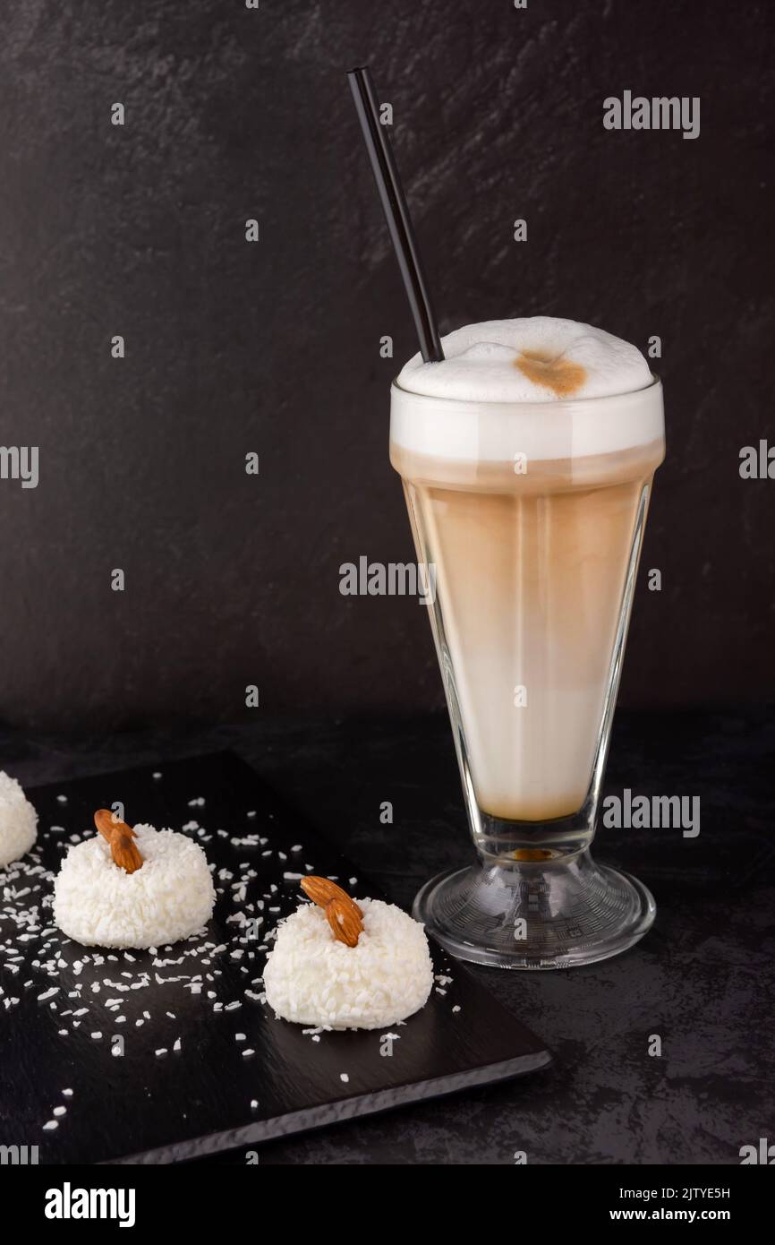 Nahaufnahme eines Barista, der in einem Geschäft oder Café Kaffee mit Sirup und Cremeschaum für ein Dessert mit Soufflekuchen zubereitet Stockfoto