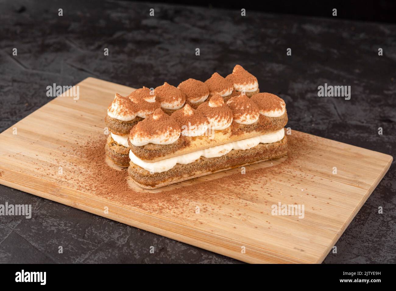 Dessert Tiramisu Kuchen auf einem Tablett auf dunklem Hintergrund in einem Café Stockfoto