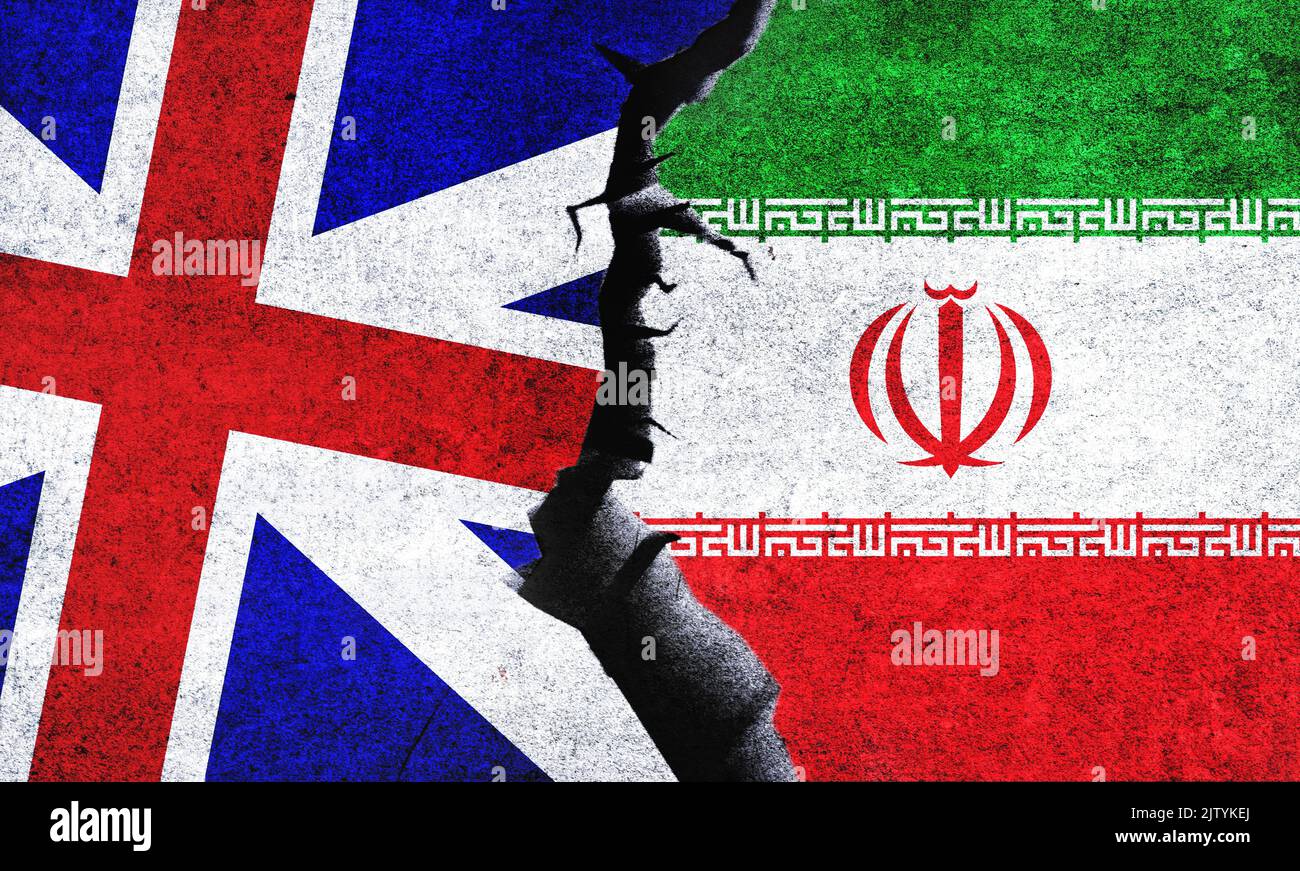 Flaggen des Vereinigten Königreichs gegen den Iran an einer Wand mit einem Riss. Konflikt zwischen dem Iran und Großbritannien. Stockfoto
