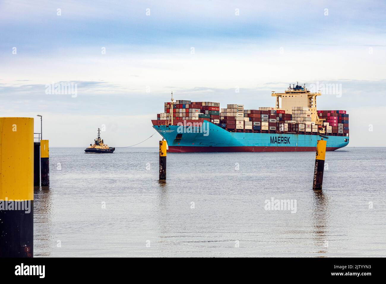 Schlepper führt das Containerschiff Maersk Luz zum Entladebereich im Überseehafen Bremerhaven Stockfoto