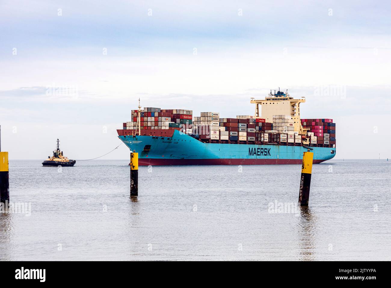 Schlepper führt das Containerschiff Maersk Luz zum Entladebereich im Überseehafen Bremerhaven Stockfoto