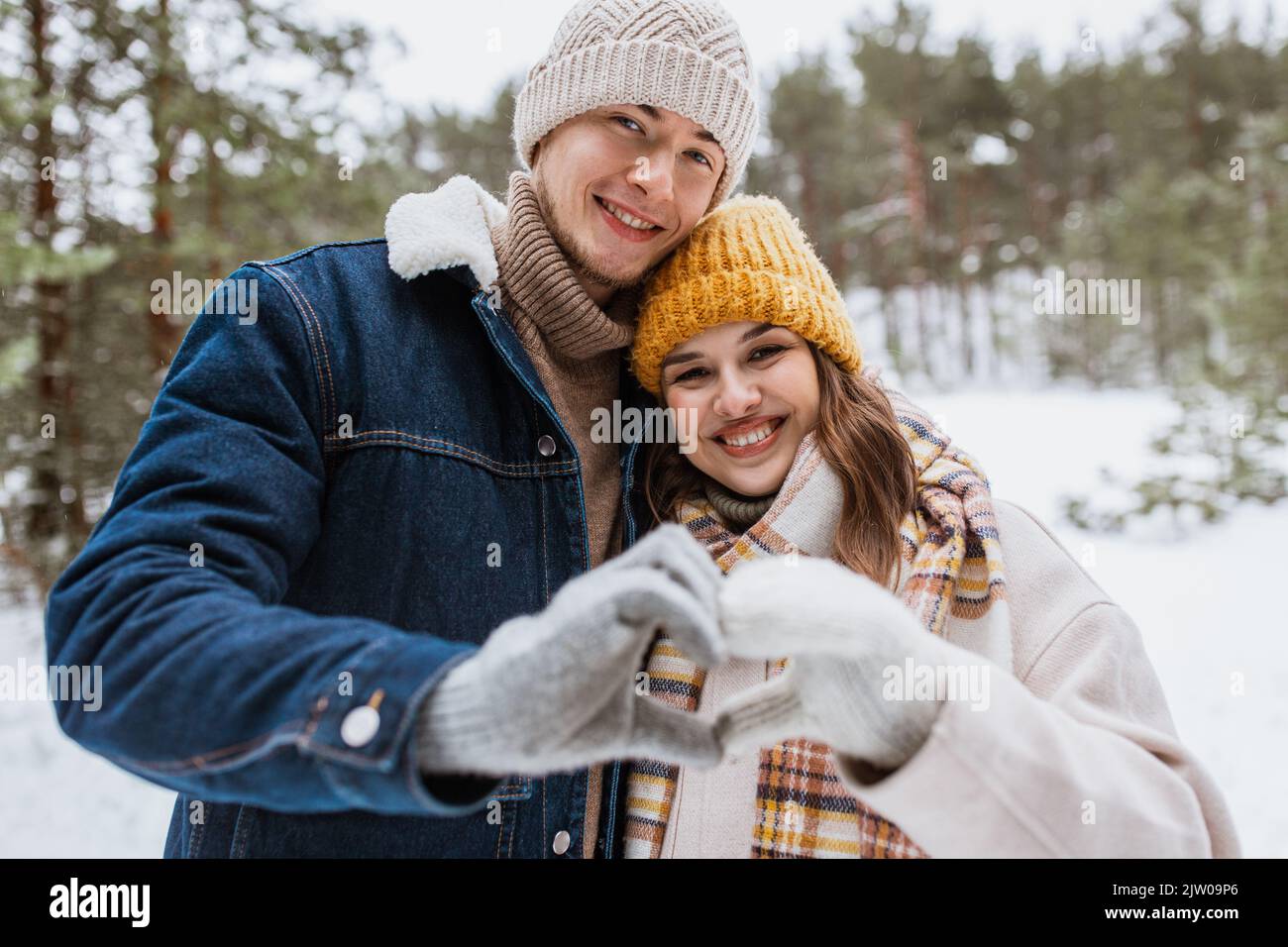 Glückliches Paar macht Hand Herz Geste im Winter Stockfoto