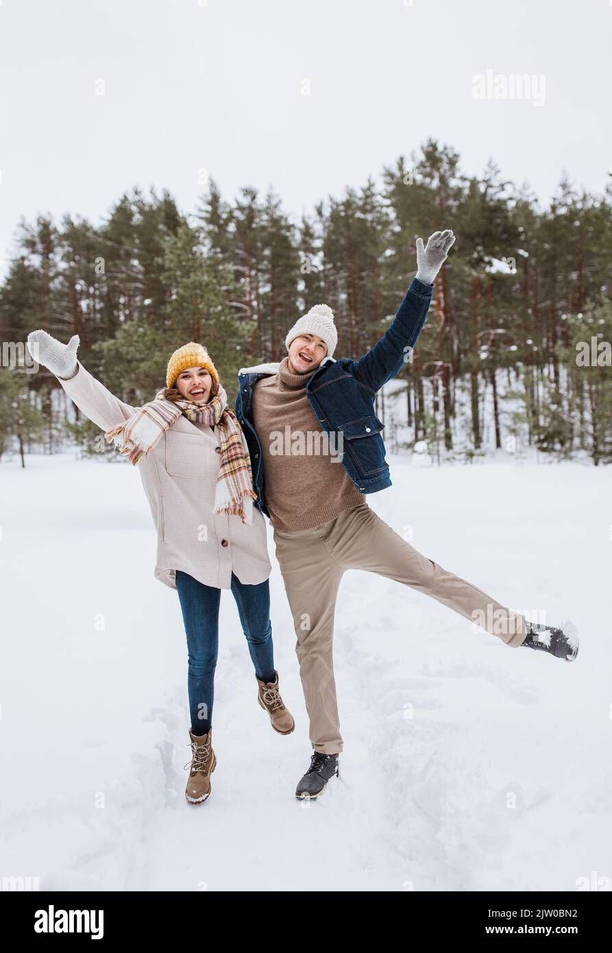 Glückliches lächelndes Paar, das Spaß im Winterpark hat Stockfoto