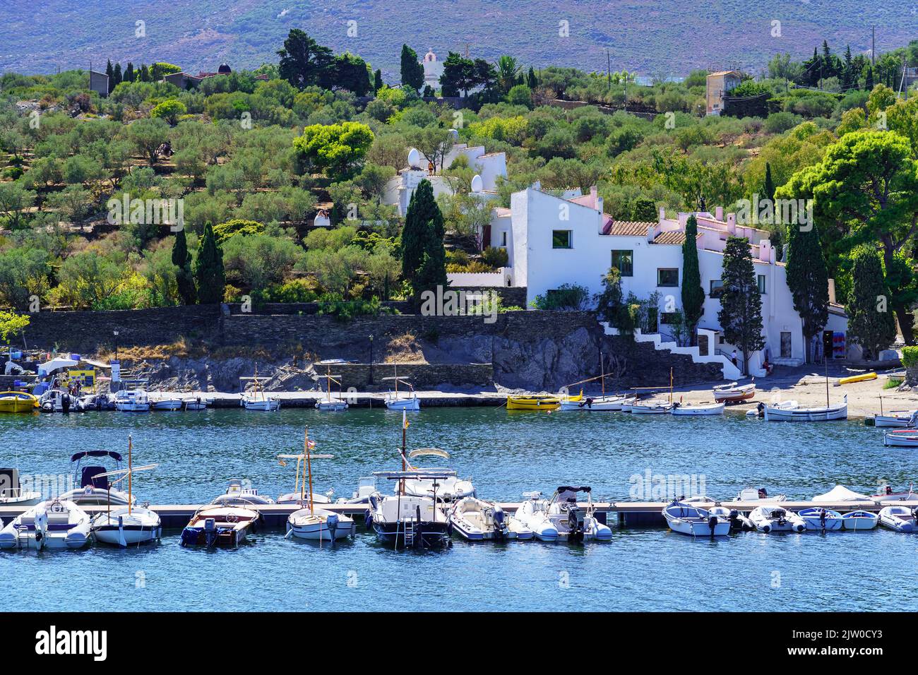 Kleine Boote dockten entlang der Küste und vor einem malerischen Dorf an der Costa Brava, Spanien. Stockfoto
