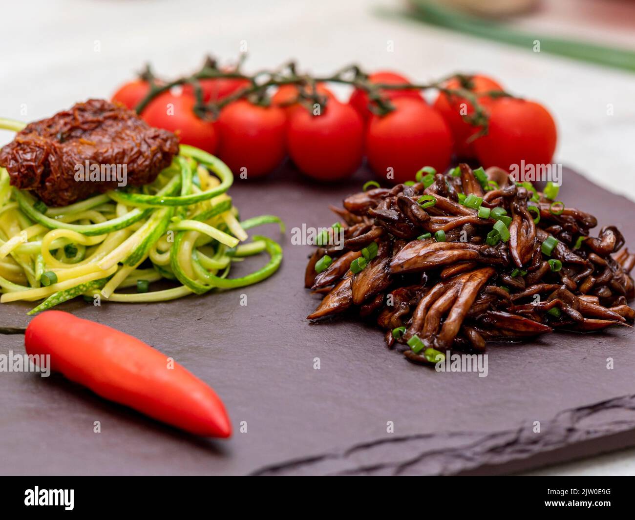 Zucchini-Spaghetti mit getrockneten und getrockneten Tomaten Stockfoto