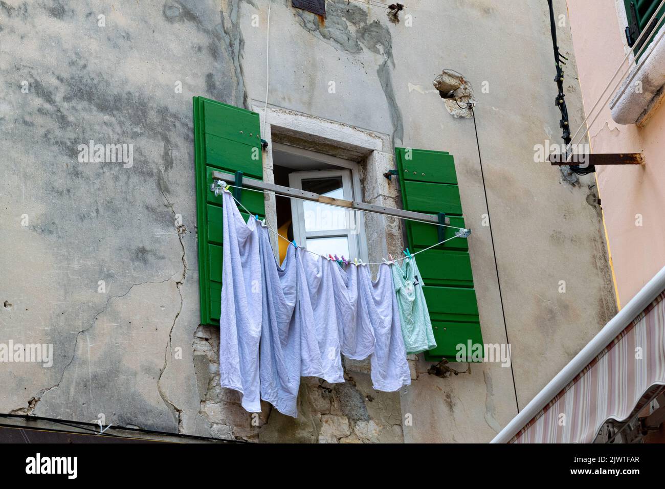 Hausarbeiten des täglichen Lebens - Kleidung hängt vor einem offenen Fenster in Rovinj Kroatien Stockfoto