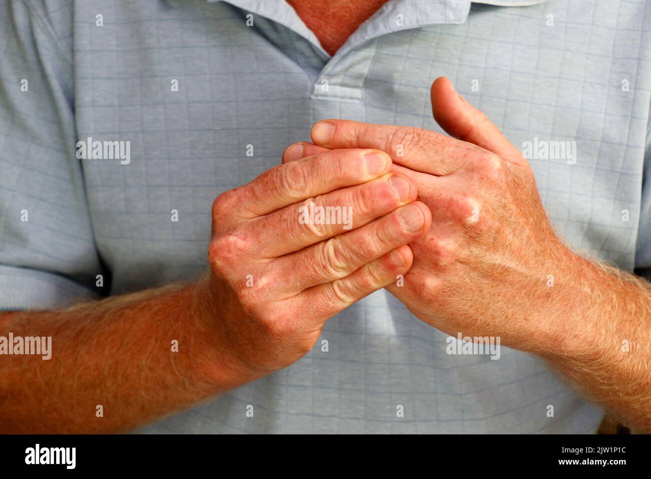 Die rechten Finger eines erwachsenen kaukasischen Mannes, der die Finger seiner linken Hand aus der Nähe massiert, um Gelenkschmerzen zu lindern. Linksseitige Handfinger bei Stockfoto