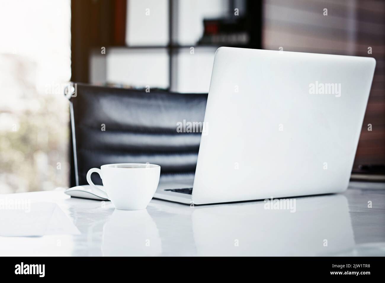 Mit den richtigen Tools von lokal auf global umsteigen. Nahaufnahme eines Laptops und einer Kaffeetasse auf einem Schreibtisch. Stockfoto