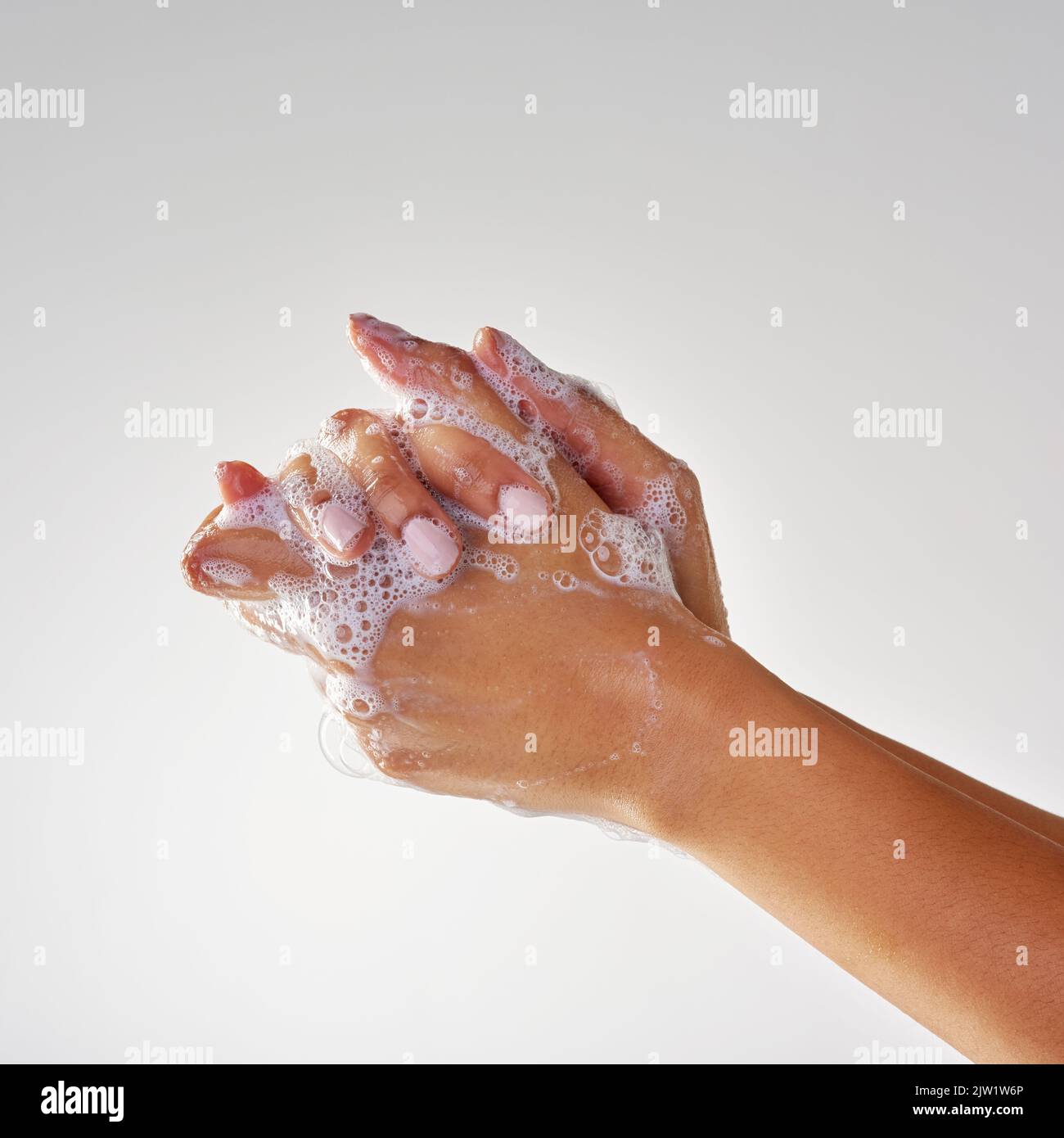 Seifige Hände. Hände, die mit Seife vor grauem Hintergrund gewaschen werden. Stockfoto