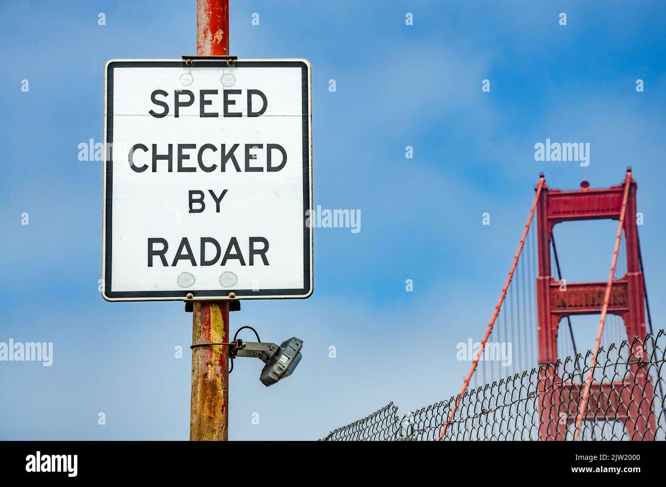 Ein weißes Straßenschild auf der Golden Gate Bridge in San Francisco warnt die Fahrer, dass die Geschwindigkeit per Radar überprüft wird. Stockfoto