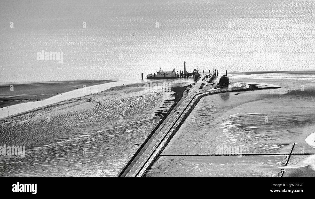 Pellworm Fähranleger hinterleuchtet, Sonnenlicht glitzert auf dem Meer, Schwarz-Weiß-Foto, Luftaufnahme, Pellworm Island, Nordfriesland, Schleswig-Holstein Stockfoto