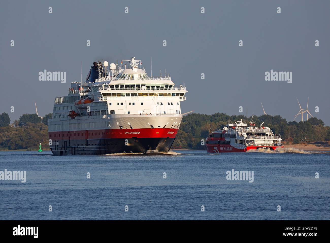 Das Schiff MS Otto Sverdrup, Hurtigruten, verlässt im Abendlicht den Hamburger Hafen auf der Elbe und trifft auf den Hochgeschwindigkeits-Katamaran Halunder Jet of Stockfoto