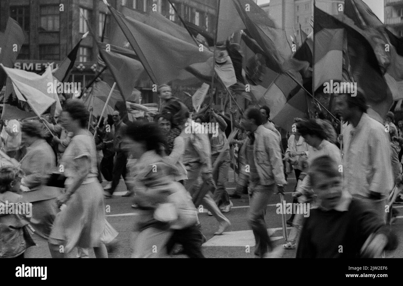 DDR, Berlin, 01. 05. 1987, 1. Mai-Kundgebung 1987 auf der Karl-Marx-Allee, Regenschauer, Teilnehmer laufen, Fahnen winken Stockfoto