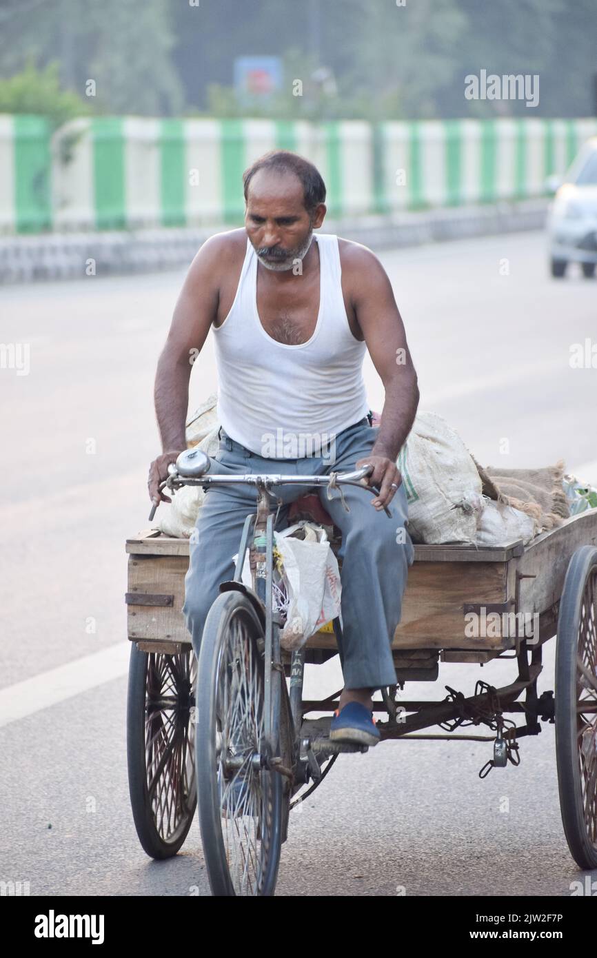 Mann, der morgens in Neu-Delhi, Indien, einen Fahrrad-Rikscha fährt. Stockfoto