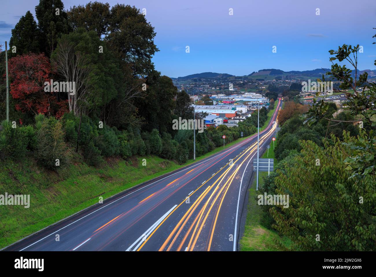 Die leichten Spuren von Autos, die in der Dämmerung von der Arbeit nach Hause fahren. Tauranga, Neuseeland Stockfoto