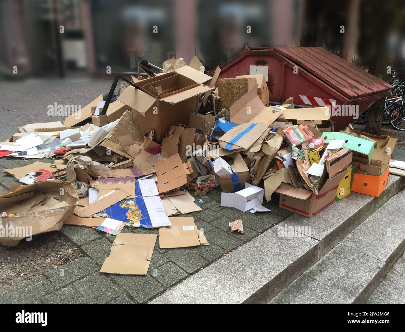 Altpapiersammlung mit Kartonagen, Papier und Mulde am Straßenrand Stockfoto