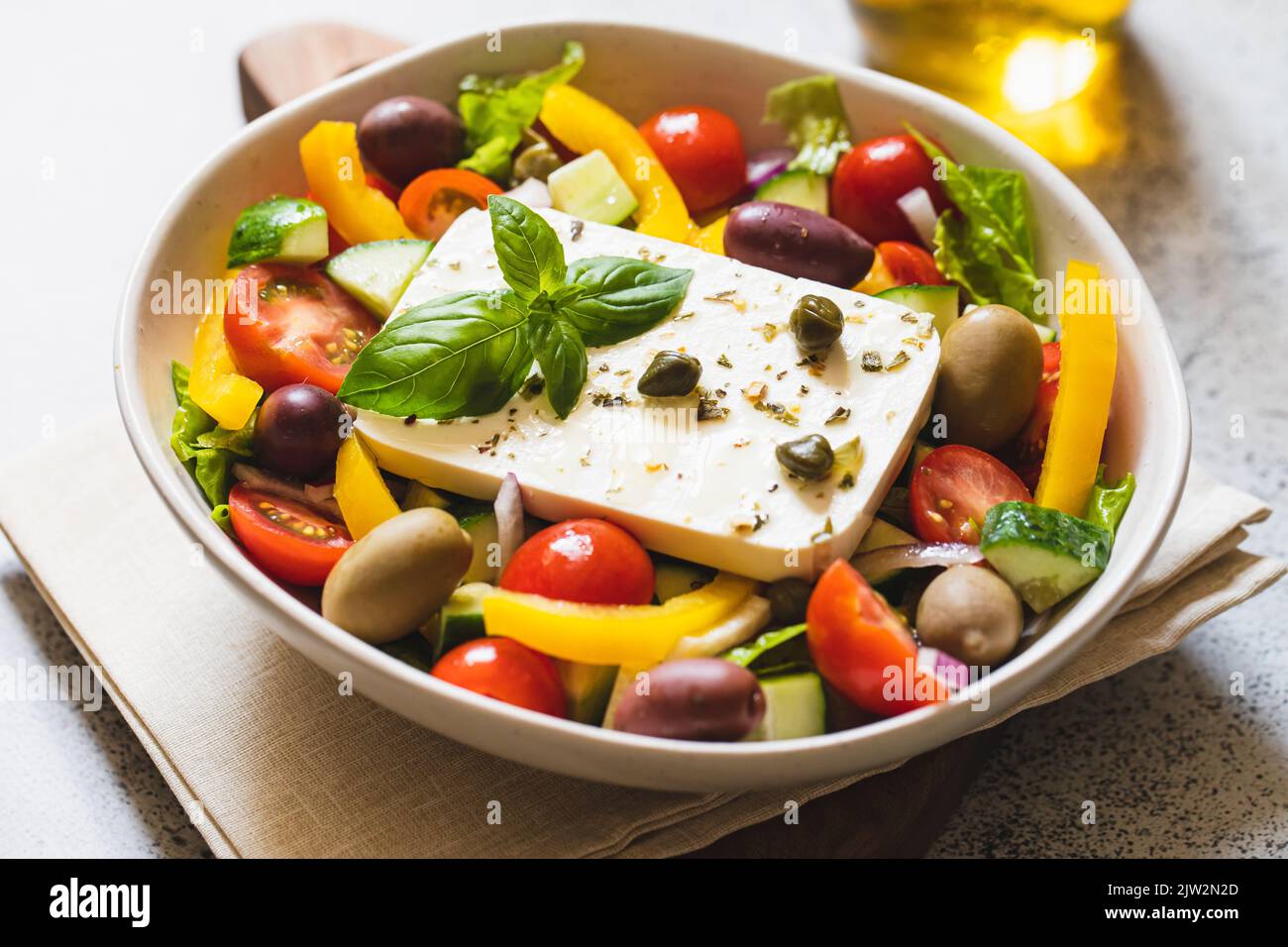 Klassischer griechischer Salat aus frischer Gurke, Tomaten, Paprika, Salat, roten Zwiebeln, Feta-Käse und Oliven mit Olivenöl. Stockfoto