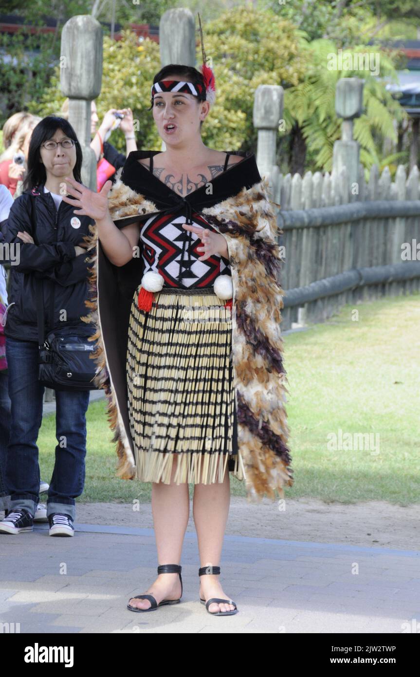 Eine Maori-Frau gibt einer Besuchergruppe im Te Puia Maori Arts and Crafts Institute innerhalb von Whakarewarewa in einen Einführungsvortrag über die Maori-Kultur Stockfoto