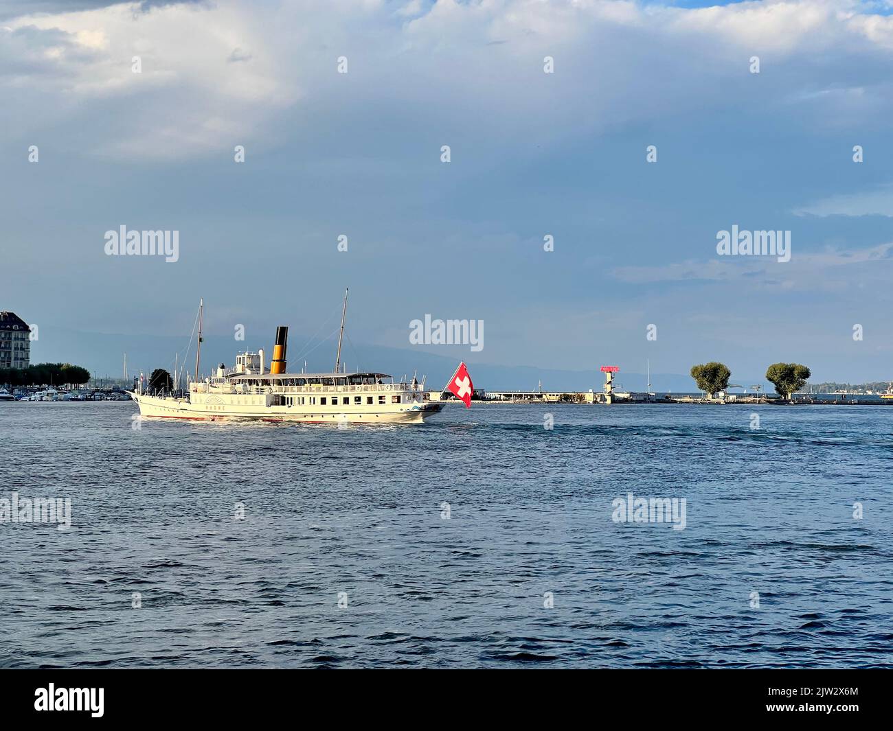 Schweizer Ausflugsboot auf dem Genfer See mit schweizer Flagge. Dieses Dampfschiff überquert den See mit Touristen. Bootstour ab Genf Stockfoto