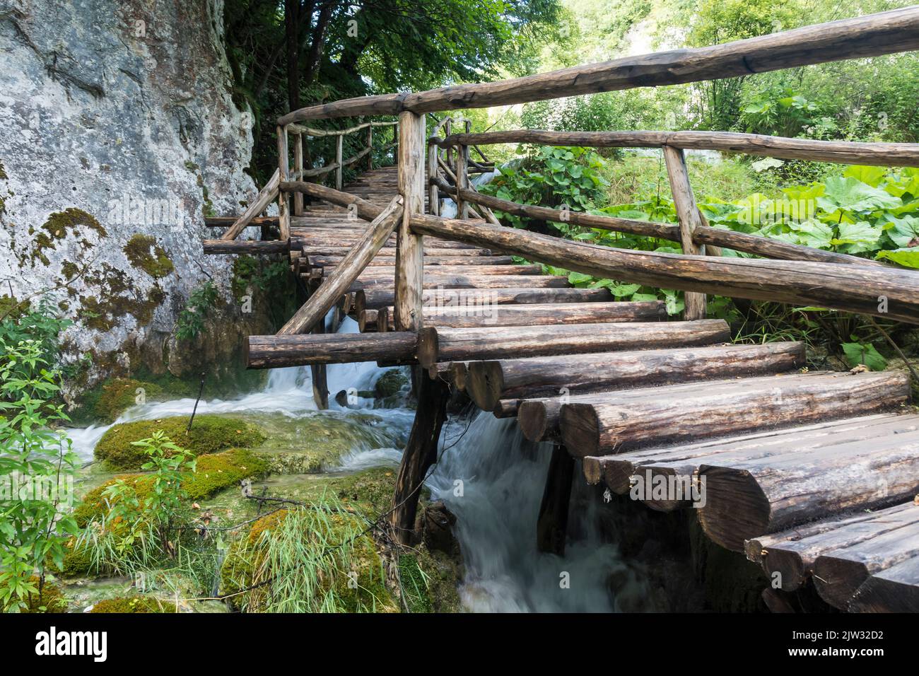 Eine Holzbrücke über eine Kaskade im Nationalpark Plitvicer Seen, Kroatien, Europa. Stockfoto