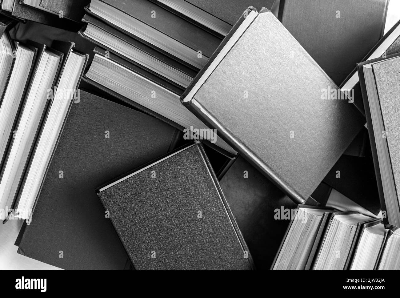 Bücher stapeln sich. Bildung, Literaturkonzept. Schwarz und Weiß. Viele Hardcover-Romane. Hochwertige Fotos Stockfoto