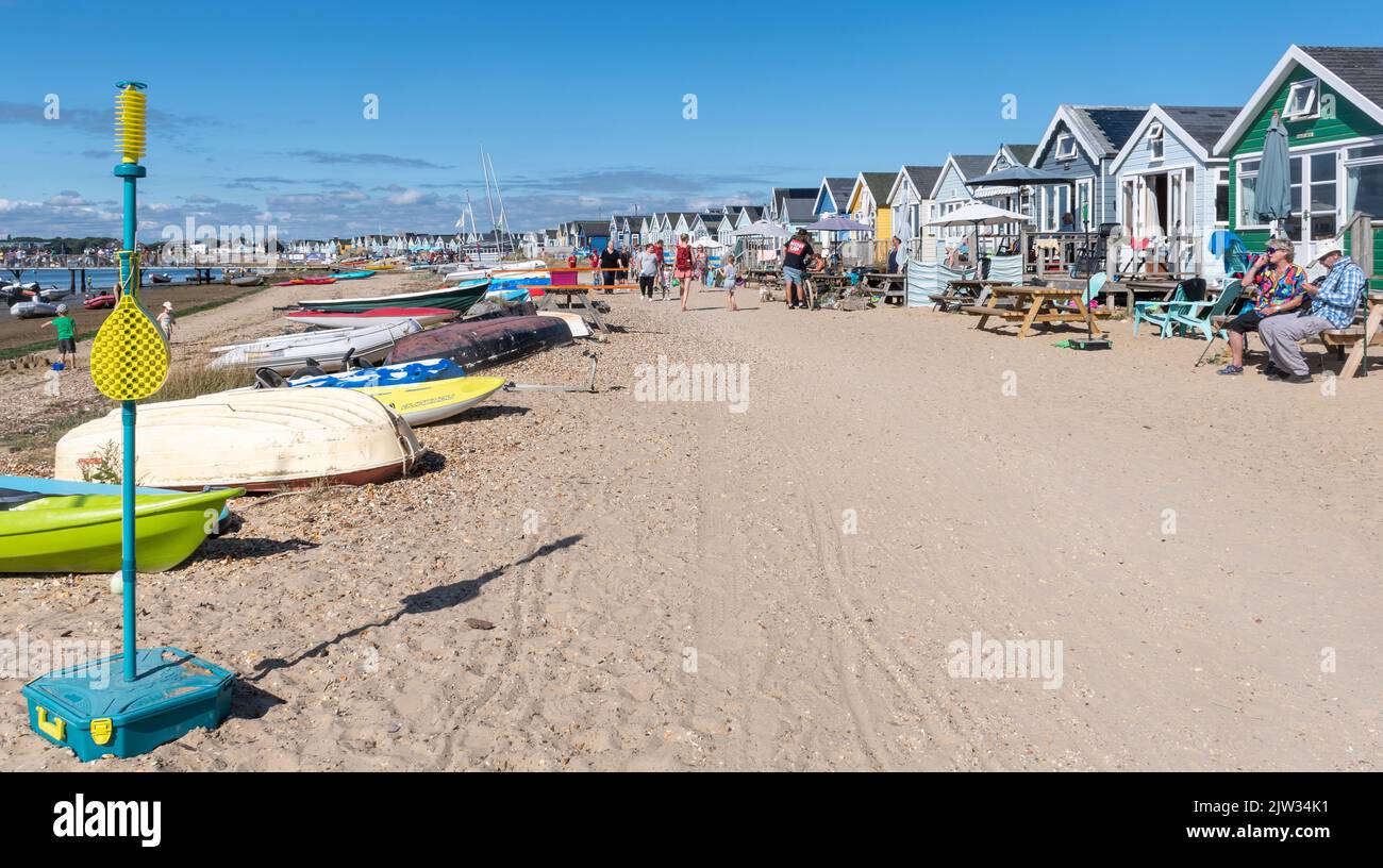Strandhütten auf der Mudeford Sandbank in der Nähe von Hengistbury Head, Dorset, England, Großbritannien, beschäftigt mit Menschen im Urlaub an einem sonnigen Sommertag Stockfoto