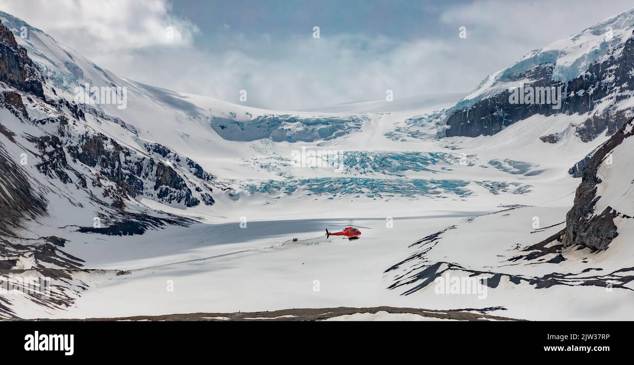 Eisgekühlte Fahrt. Ein Hubschrauber, der am Athabasca-Gletscher vorbeifliegt. Der Icefields Parkway, Kanada. Stockfoto