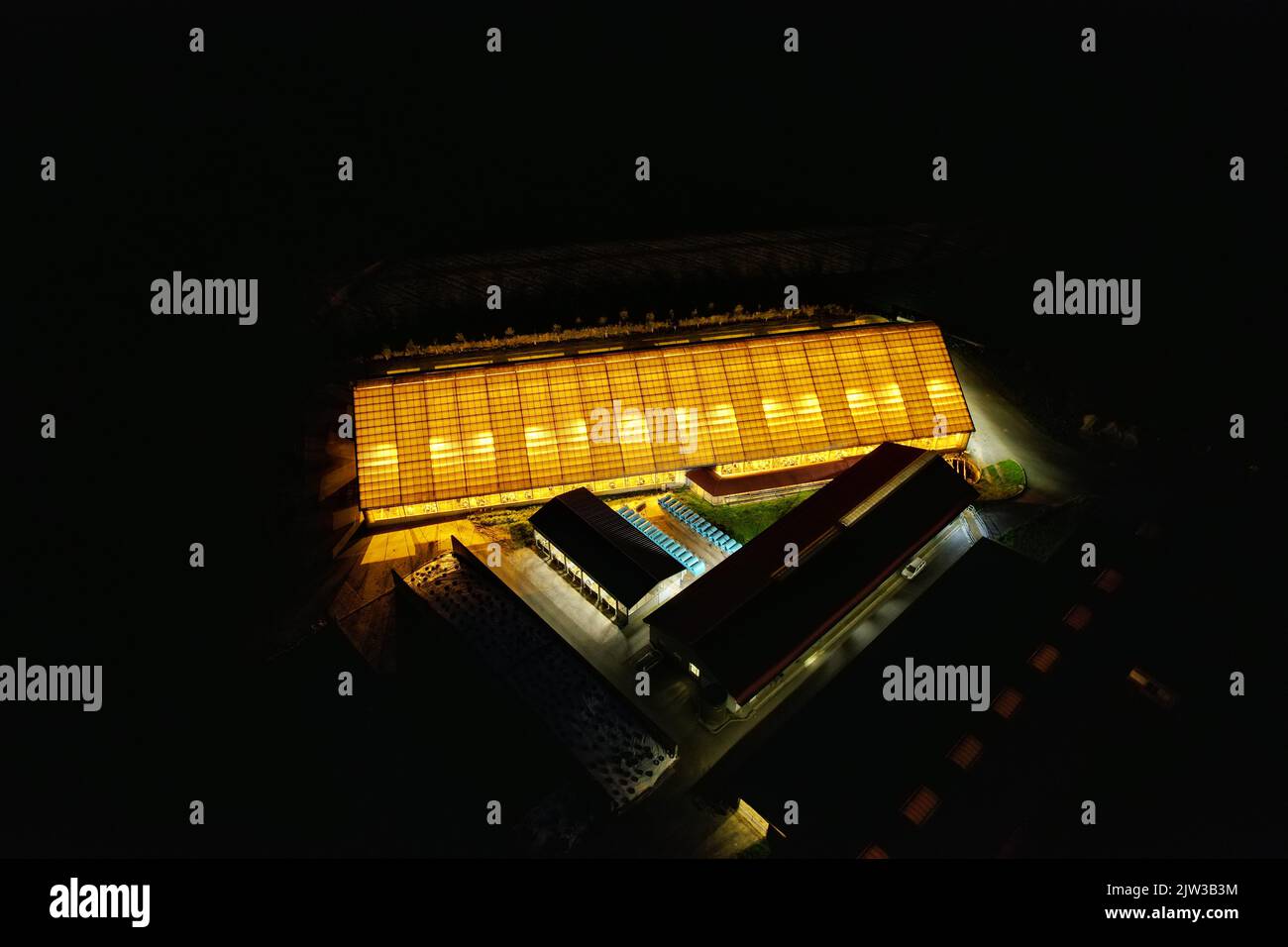 Bauernhof Kuh-Haus Luftbild Nacht Panorama von leuchtenden, Kuhstall Luftdrohne Ansicht, leuchtende Lichter durch helles Dach in dunkler Nacht, Tschechische republik, Europa Stockfoto