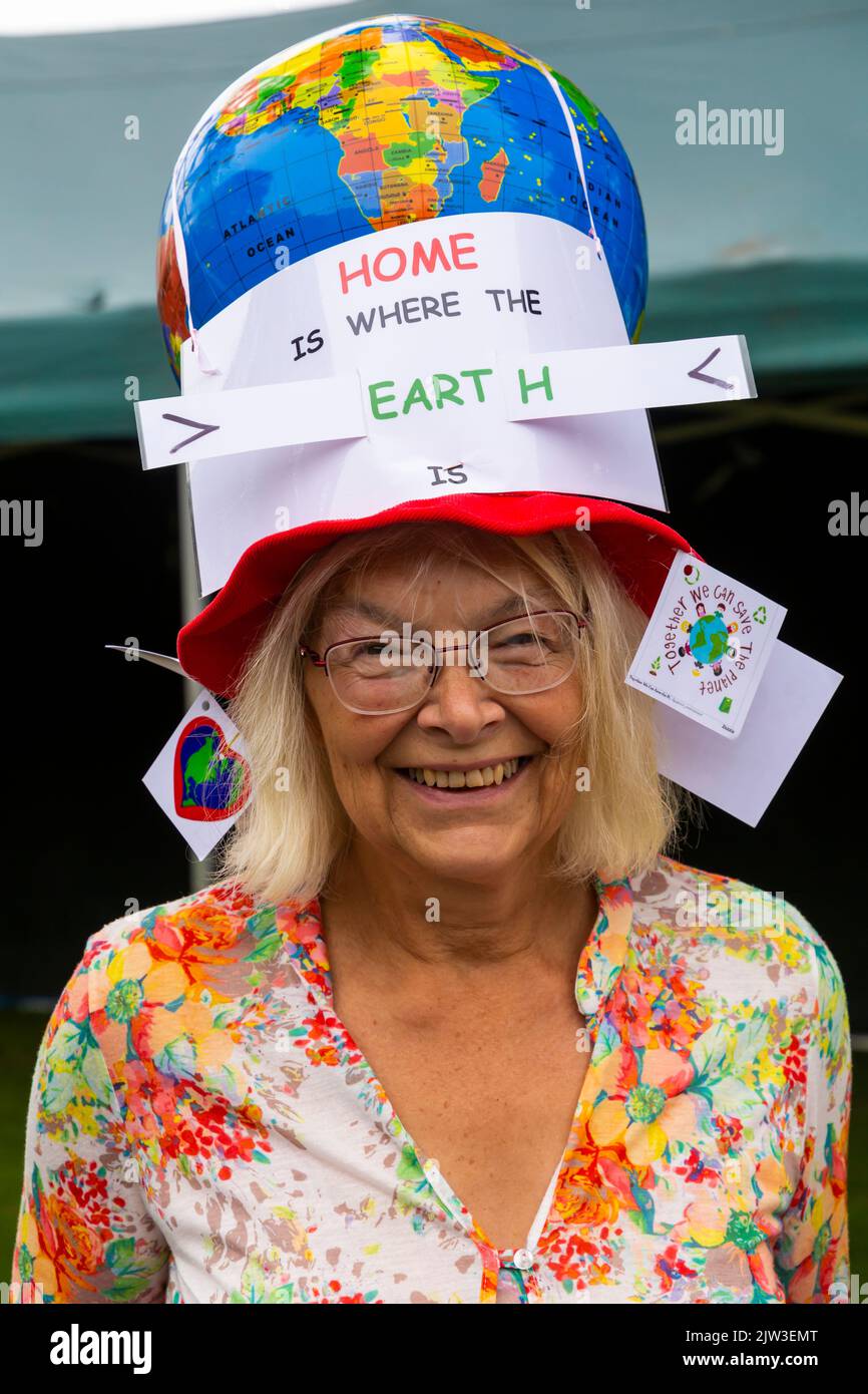 Bridport, Dorset, Großbritannien. 3.. September 2022. Eine Vielzahl von Stil und schrulligen Hüten, die von Menschen und Hunden beim Bridport hat Festival in Dorset hergestellt und getragen werden. Die Frau, die ihr Zuhause trägt, ist der Ort, wo die Erde ist und wo der Erdball Hut ist. Quelle: Carolyn Jenkins/Alamy Live News Stockfoto