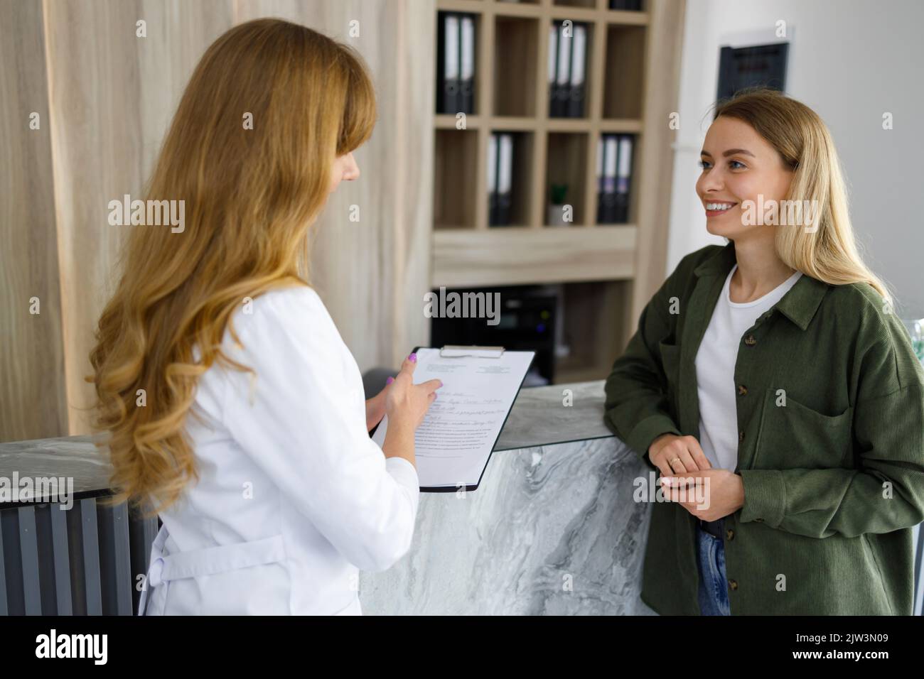 Zwei Ärztin und Patientin sprechen in einer modernen Privatklinik Stockfoto