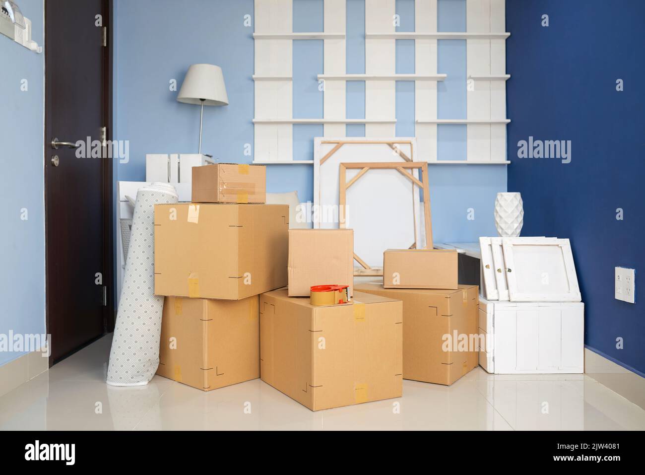 Mehrere Kartons mit Haushaltsgegenständen und Möbeln im leeren Raum der neuen Wohnung Stockfoto