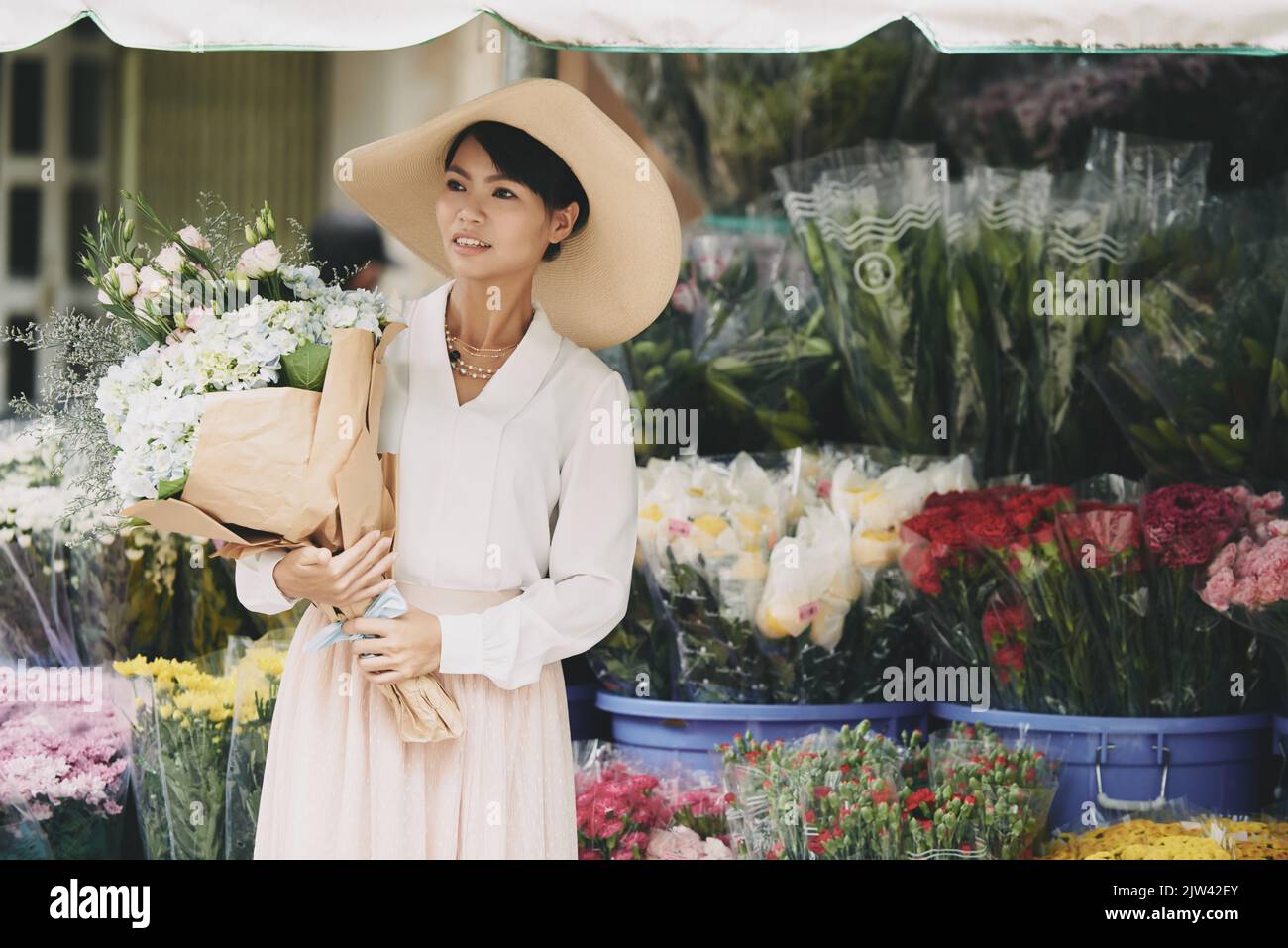 Frau mit großem Blumenstrauß auf dem Blumenmarkt Stockfoto
