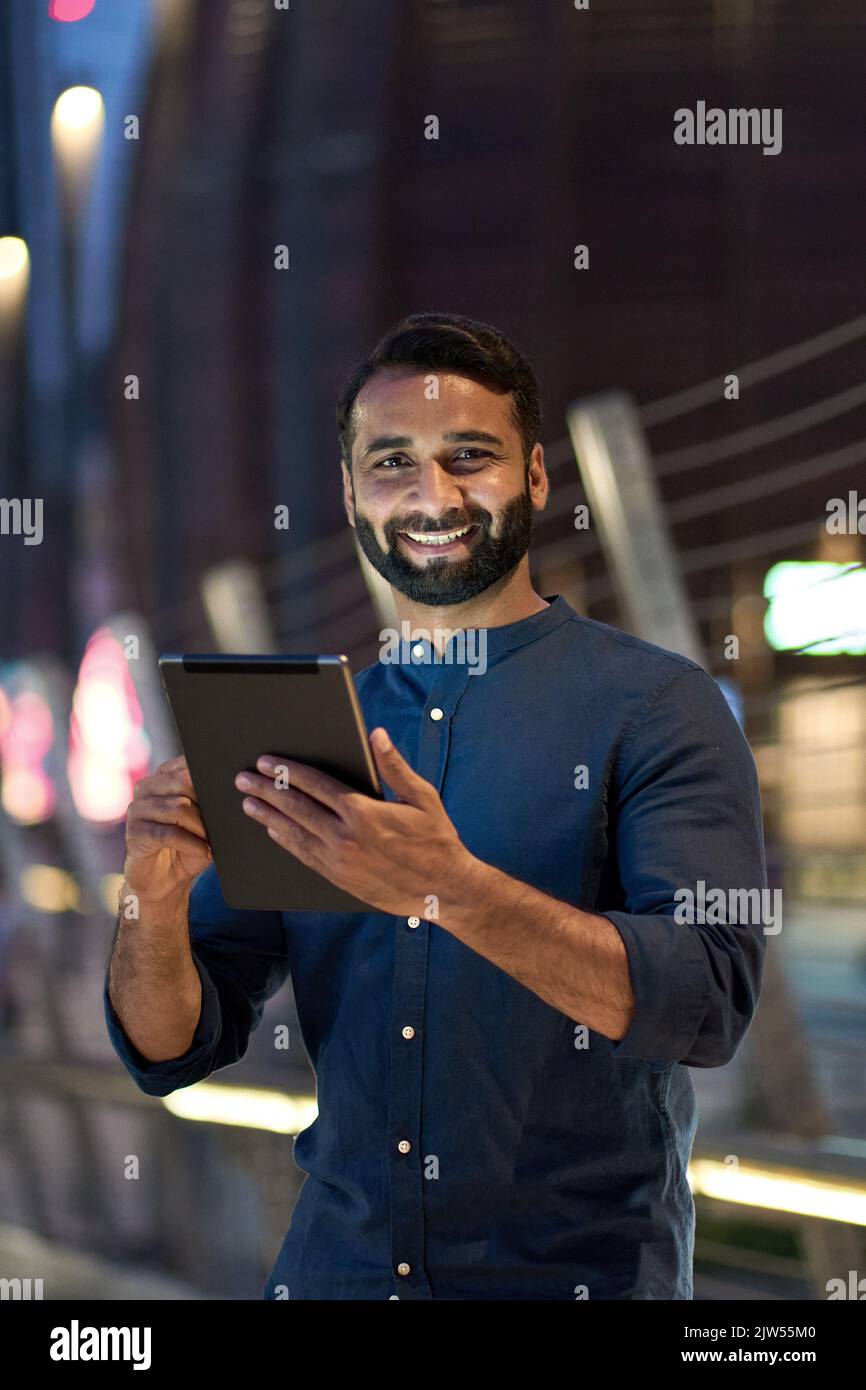 Happy indian Business man mit digitalen Tablet im Freien in der Nacht Stadt, vertikal. Stockfoto