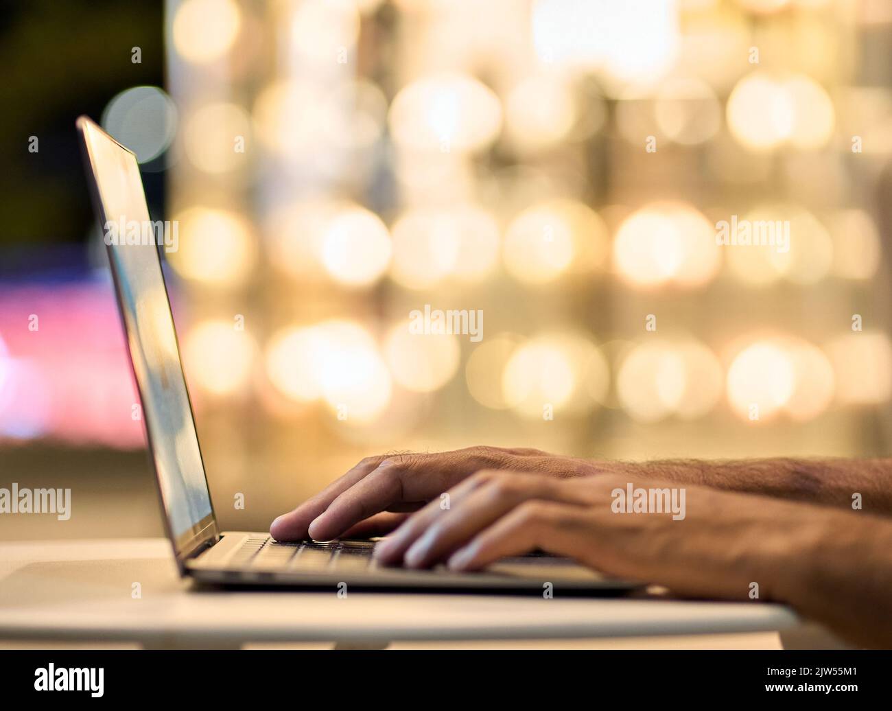 Geschäftsmann Hände tippen auf Laptop-Tastatur auf Nachtlicht Hintergrund. Stockfoto