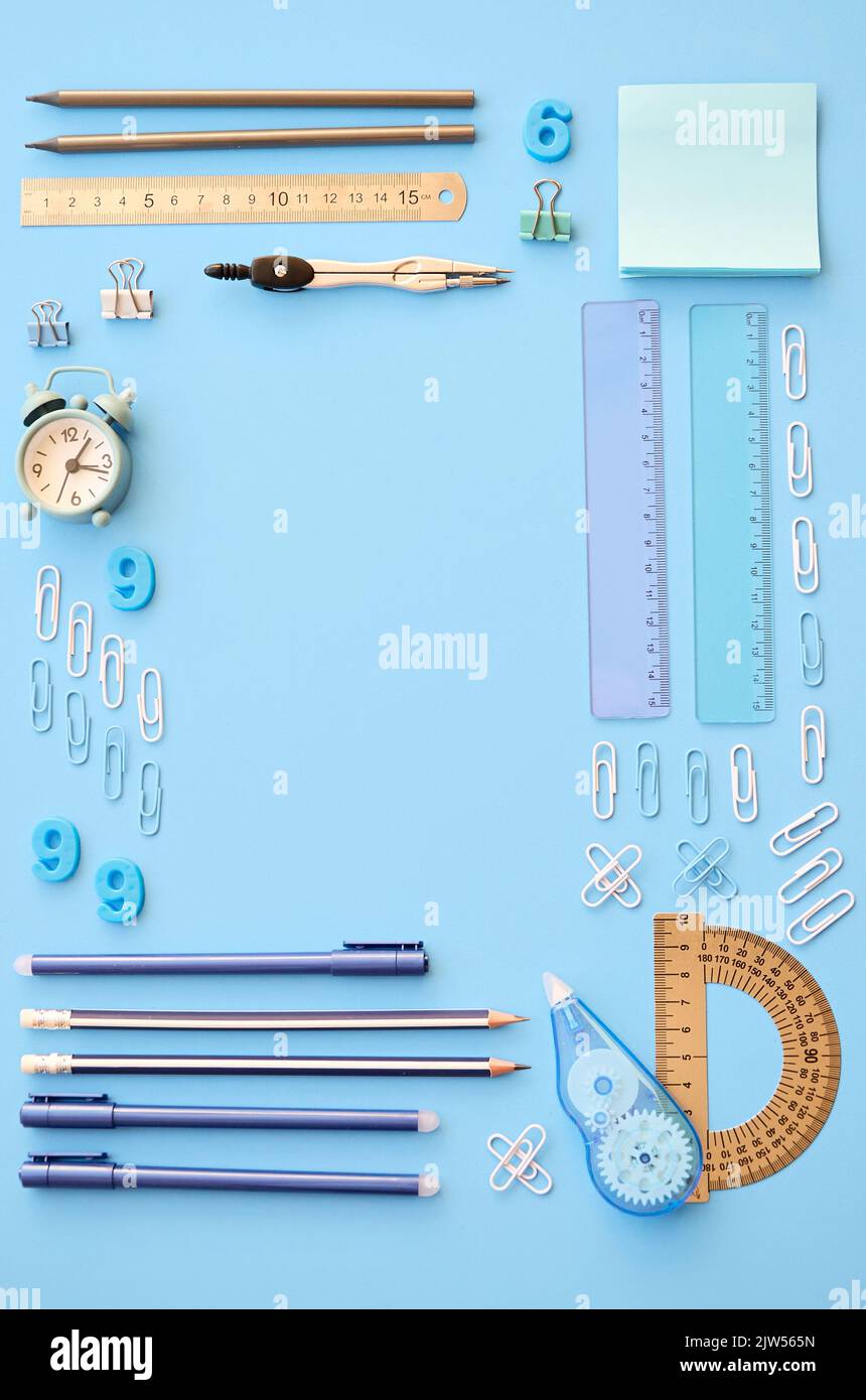 Schulzubehör Schreibwaren auf blauem Hintergrund, geometrische flache Laie. Stockfoto