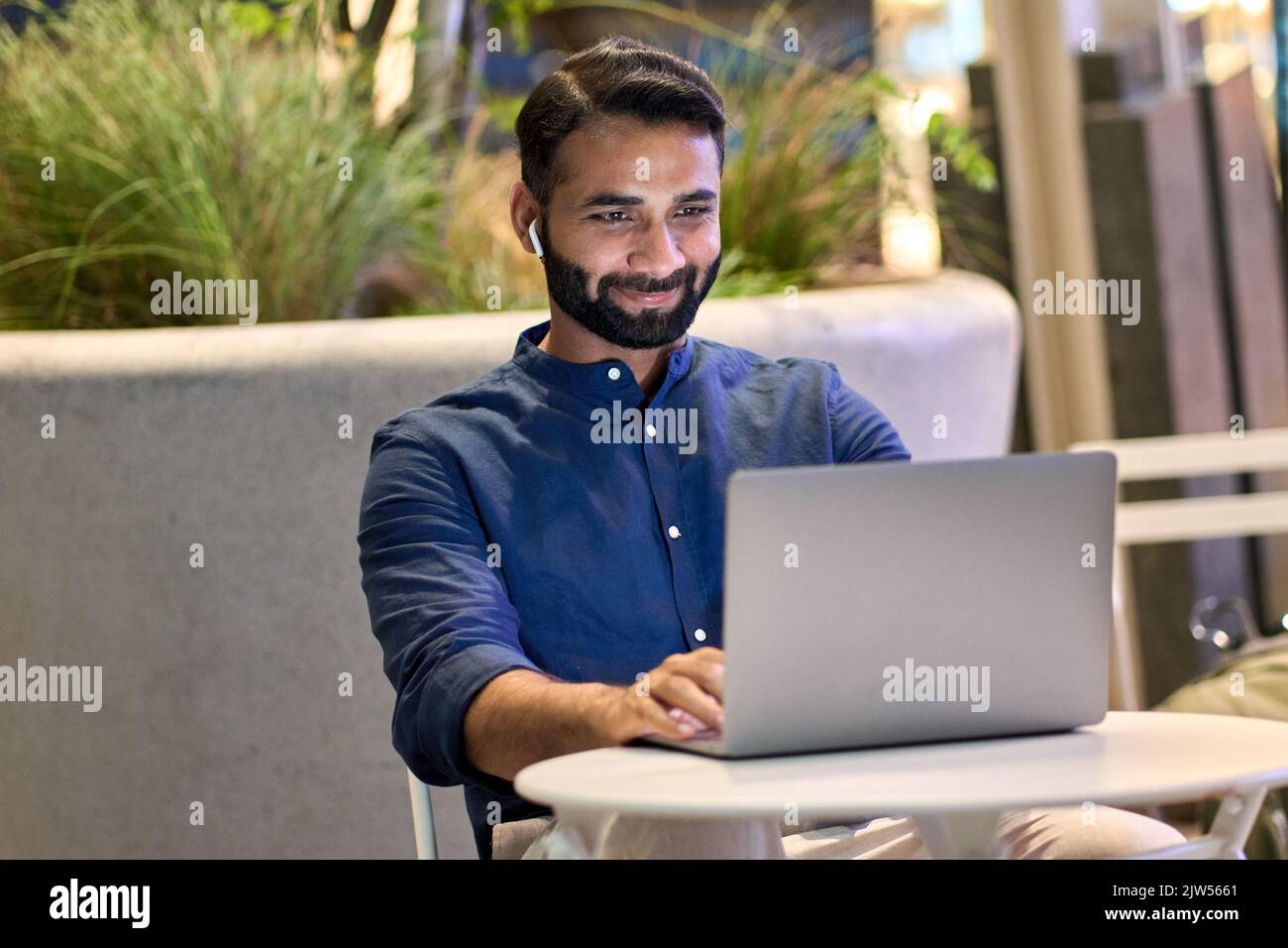 Indischer Geschäftsmann mit virtuellen Meeting-Videoanruf im nächtlichen Stadtpark. Stockfoto