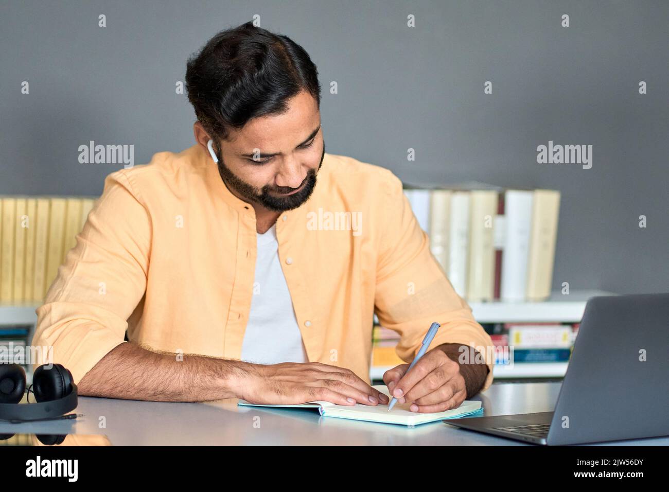 Indischer Geschäftsmann schreibt Notizen während des online-Webinars zum elearning-Kurs. Stockfoto