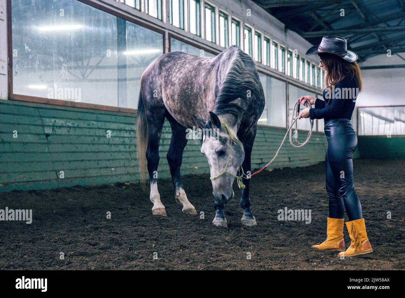 Ein hübsches kaukasisches Weibchen in einem Cowboy-Stil Hut mit einem Pferd Stockfoto