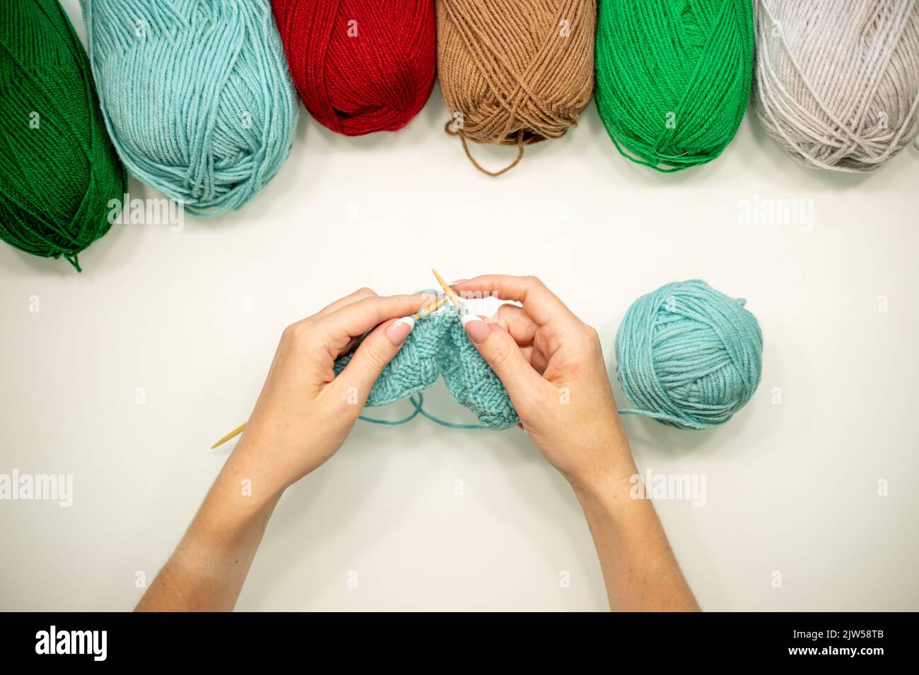 Frau Hände Strickmütze mit Nadeln und Garn. Stockfoto