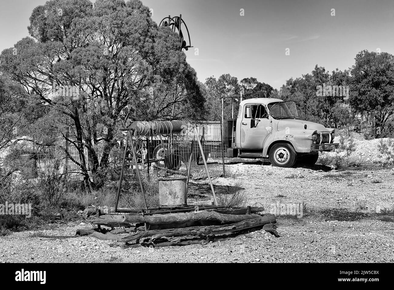 Schwarz-weißer Kontrast offener Minenschachtbrunnen und Rost-ute-LKW in der Lightning Ridge Opal-Bergbaustadt im NSW-Outback, Australien. Stockfoto