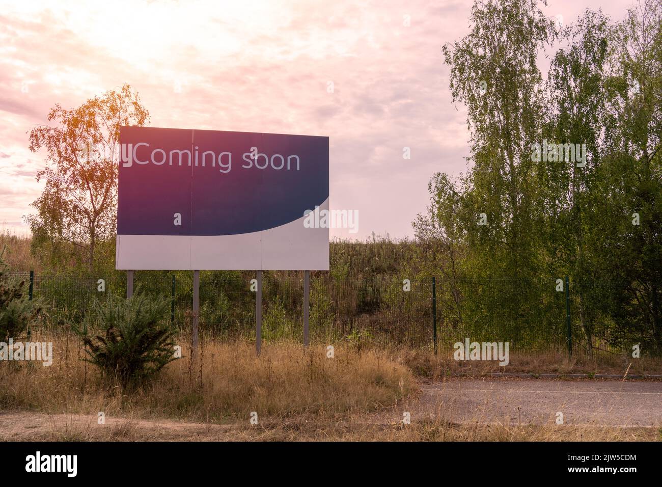 Blick auf den Sonnenuntergang auf ein großes Straßenschild mit Comin Soon-Schild Stockfoto