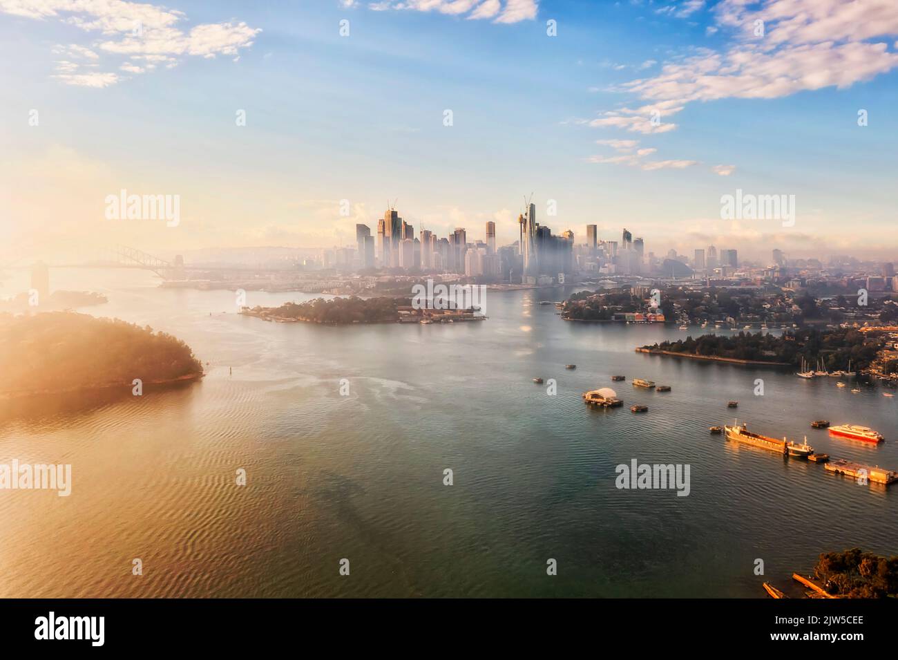 Sonnenlicht, Nebel, Nebel und Fluss rund um die CBD-Architektur von Sydney sind Wahrzeichen der Stadt bei Sonnenaufgang. Stockfoto