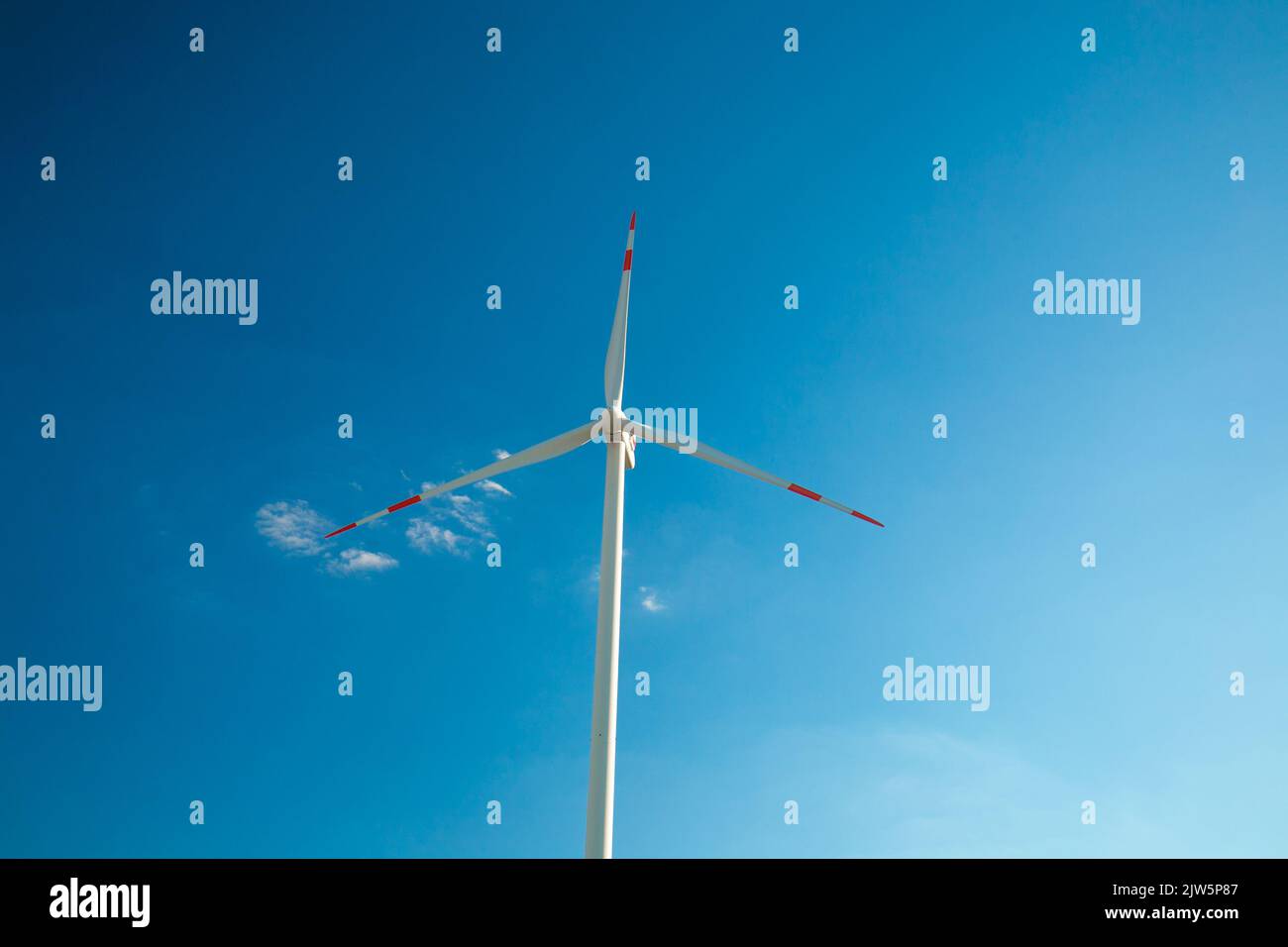 Windgenerator auf einem blauen Himmel Hintergrund.natürliche Energie.Alternative natürliche Energiequelle. Erneuerbare Energiekosten.Windmühle erneuerbare Energie. Stockfoto