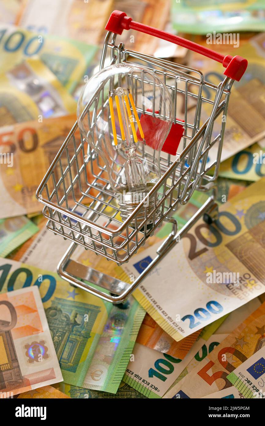 Stromrechnungen.steigende Strompreise in Europa. Glühbirne im Warenkorb, Euro-Rechnungen.Krise der Energieproduktion in den EU-Ländern Stockfoto