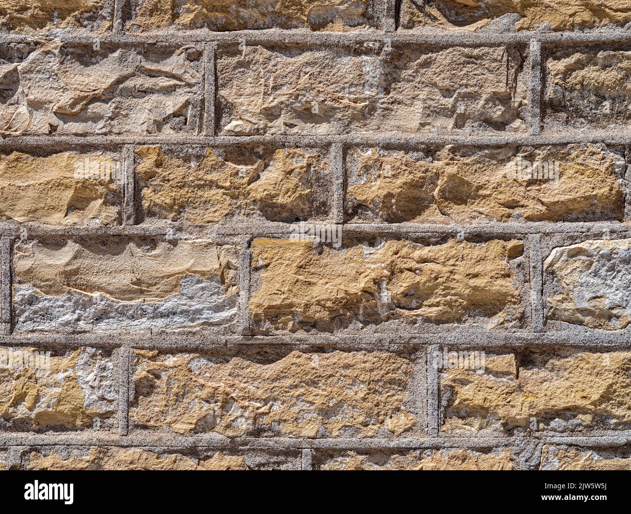 Details einer sonnendurchfluteten hellbraunen Ziegelwand Stockfoto