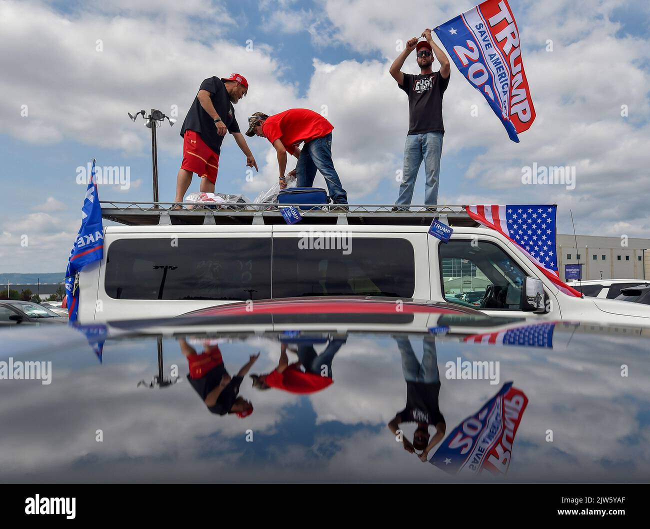 Wilkes Barre Township, Vereinigte Staaten. 03. September 2022. Bei einer Trump-Kundgebung stehen drei Männer auf dem Dach eines Transporters, der auf einem Parkplatz Trump-Flaggen schwenkt. Der ehemalige Präsident Donald Trump hielt eine Kundgebung in Wilkes-Barre-Barre Township ab. Schätzungsweise 10.000 Menschen nahmen daran Teil. Ein Großteil des Parkplatzes bestand aus einer Reihe von Menschen, die darauf warteten, hineinzukommen. (Foto von Aimee Dilger/SOPA Images/Sipa USA) Quelle: SIPA USA/Alamy Live News Stockfoto