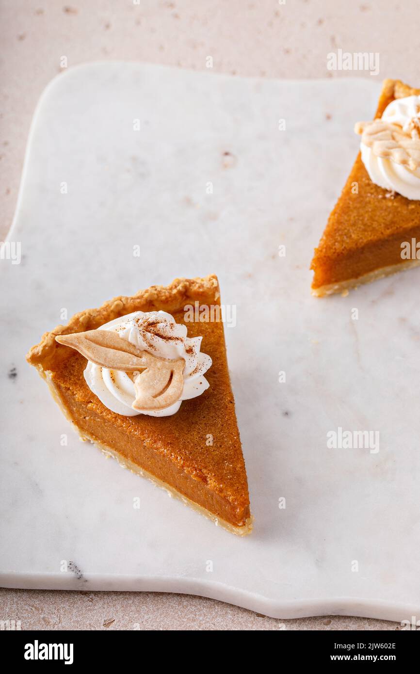 Kürbiskuchenscheiben mit Schlagsahne garniert Stockfoto