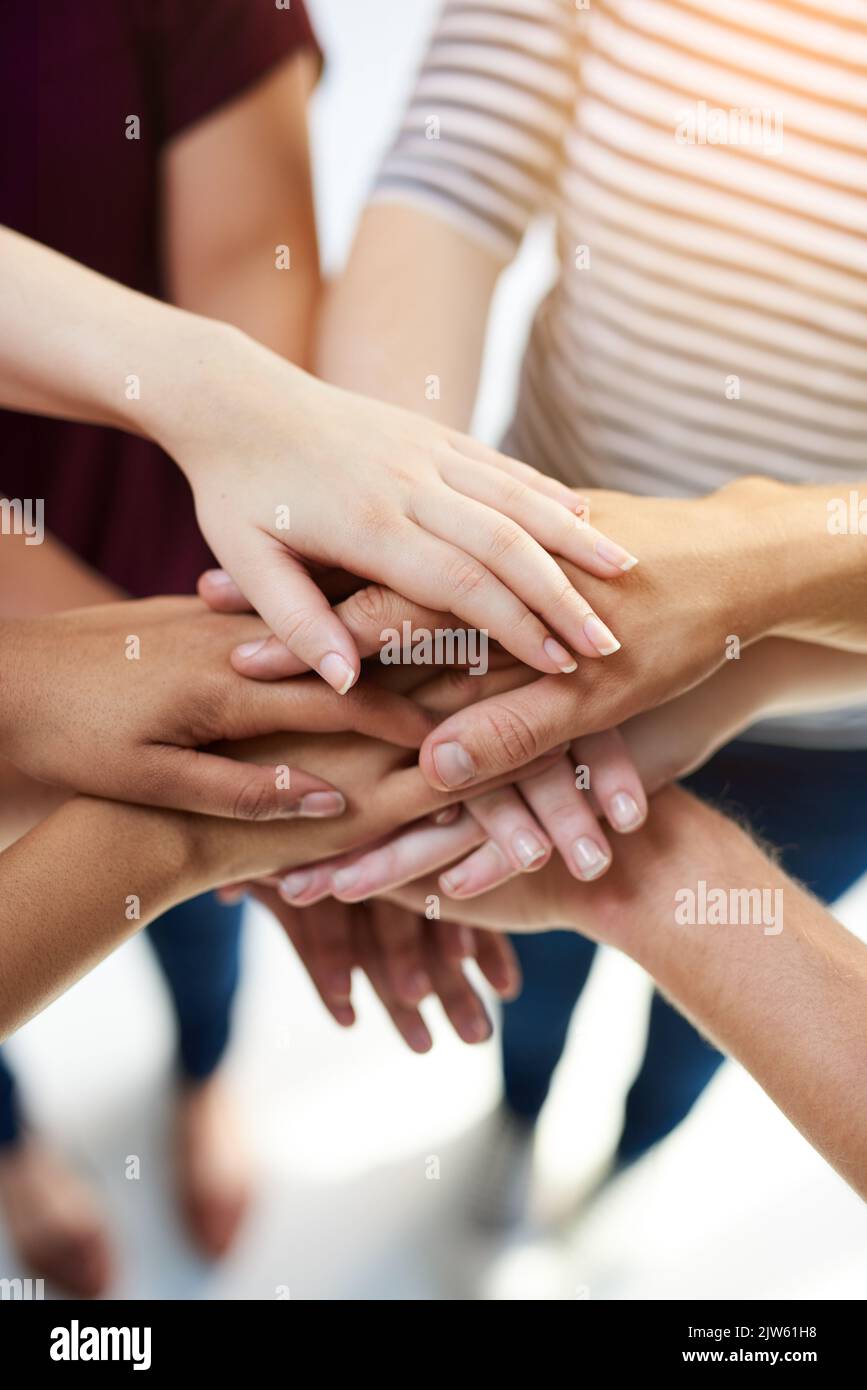 Einheit und Vielfalt. Eine Gruppe von Menschen, die ihre Hände zusammenlegen. Stockfoto