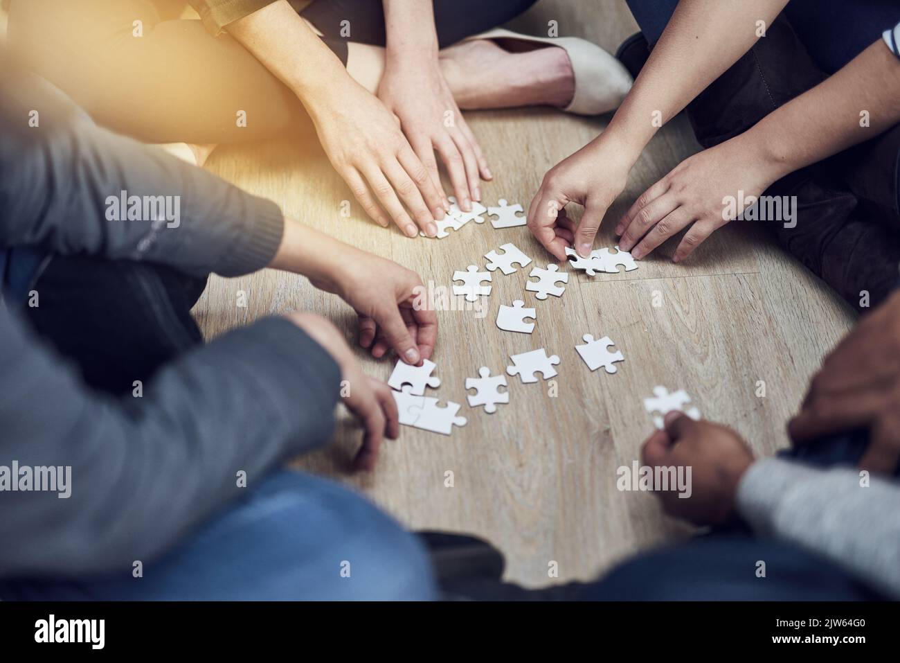 Planung des Puzzles. Eine Gruppe von Menschen, die ein Puzzle zusammen bauen. Stockfoto