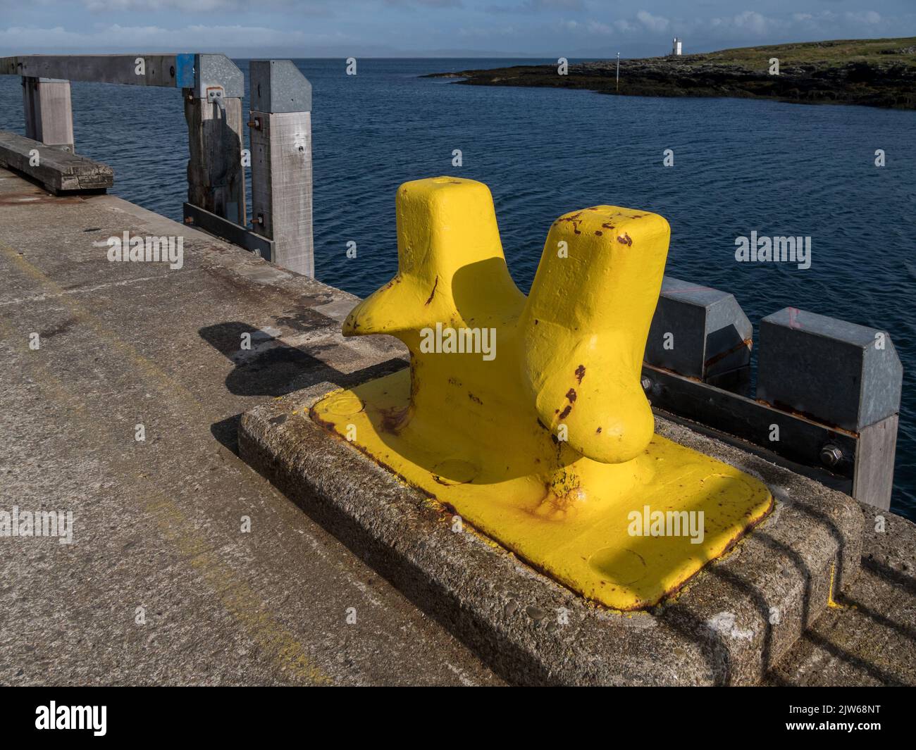 Leuchtend gelb lackierter Fährenanlegeplatz am Scalasaig Ferry Terminal Pier, Isle of Colonsay, Schottland, Großbritannien Stockfoto